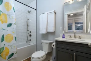 Clean bathroom design with a dark wood vanity, white porcelain toilet, and a combination tub-shower setup.
