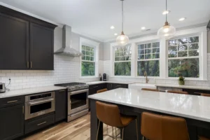 View of a spacious kitchen island with a white quartz countertop, integrated sink, and premium stainless steel appliances.